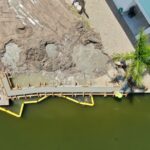 Aerial view of new seawall panels and cap forms with a turbidity barrier on Fort Myers Beach