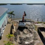 Excavator removing the failed seawall and old dock by land on Fort Myers Beach