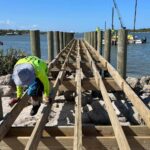 Crew framing the new Menard-May Park pier walkway over the rock shoreline in Edgewater