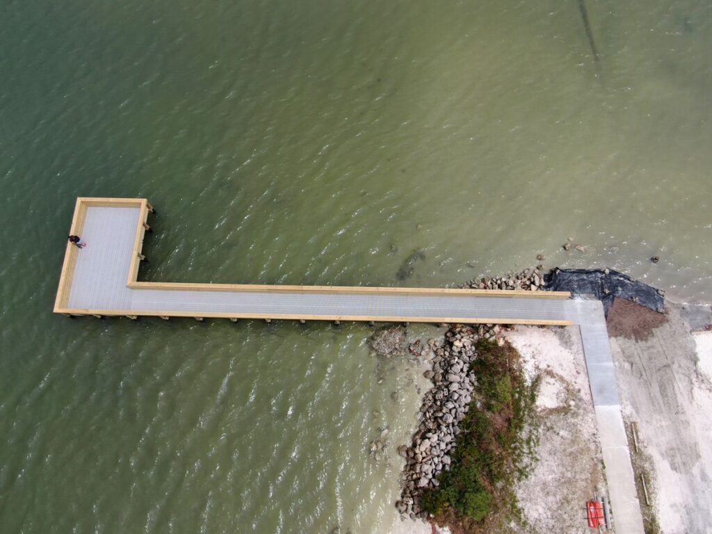 Overhead view of the finished Menard-May Park pier extending past the rock revetment