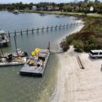 Small work barges staged in shallow water during the Menard-May Park pier replacement